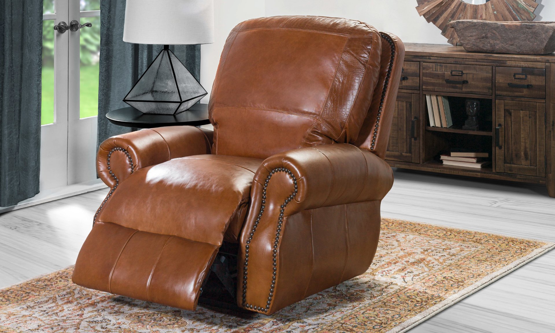 Brown leather recliner with roll arms and nail head trim.